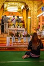 Women prohibited sign with a praying woman in buddhist temple,