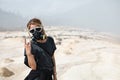 Women in protective filter mask walking around Ijen volcano crater