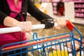 Women pushing shopping trolley in the supermarket aisles