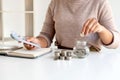 Women are putting coins in a piggy bank, glass bottle, saving money with coins, stepping into a growing business to succeed and Royalty Free Stock Photo