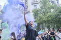 Women raising violet and green smoke flares in the air during 8M feminist strike
