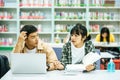 Women read books and men use laptops to search for books in libraries