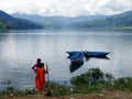 Women in red looking at Phewa Lake and mountains, Pokhara, Nepal