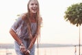 Women refreshing herself in sunny hot day with fountain at background of lake and woods