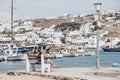 Women relaxing on a bench by the water on a sunny day in Hora Mykonos Town, Mykonos, Greece