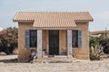 Women relaxing in the shade in front of a hous on the island of Delos, Greece