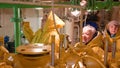 Women repairmen in yellow raincoats inspect engine room in boat in Norway.