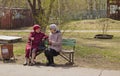 Women of retirement age sit on a bench and discuss the news
