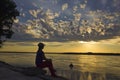 Women at river bank watching sunset