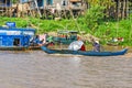 Women rowing a long-tail boat along the banks of Tonle Sap Lake