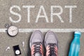 Women Running shoes and equipment on asphalt whit start inscription. Running training on hard surfaces. Runner Royalty Free Stock Photo