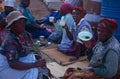 Women in rural South Africa, sat on the ground eating and drinking.