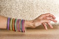 Women`s arm with multiple multi-colored bracelets