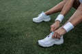 Women`s athletic legs on the green court