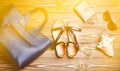 Women's bag, sandals, purse, glasses, shell on a wooden table. W