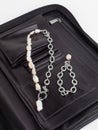 Women`s baroque pearl necklace and chain bracelet with pendant on female black leather cosmetic bag Royalty Free Stock Photo