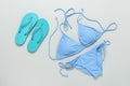 Women`s beach accessories bikini swimsuit and flip flops on a gray background. Top view, flat lay. Blue swimwear and turquoise Royalty Free Stock Photo