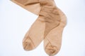 Women`s beige nylon stockings on a white background close up Royalty Free Stock Photo