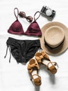 Women`s bikini, hat, sandals, camera, sunglasses on a light background, top view. Vacation beach sea fashion concept Royalty Free Stock Photo