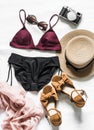 Women`s bikini, hat, sandals, headscarf, camera on a light background, top view. Vacation sea fashion concept Royalty Free Stock Photo