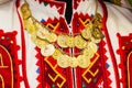 Women`s blouse with colorful hand-embroidered embellished with a necklace of gold coins