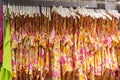 Women's bright, one-piece swimsuits hang on hangers in a clothing store.