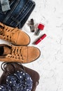 Women's clothing and accessories - suede boots, jeans, leather bag, scarf, red nail polish and lipstick Royalty Free Stock Photo