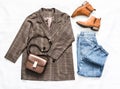 Women`s clothing set - plaid jacket, mom`s blue jeans, brown crossbody bag and suede chelsea boots on a light background, top vi Royalty Free Stock Photo