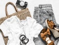 Women`s clothing summer - grey mom`s jeans, suede brown wedge sandals, white cotton t-shirt, eco bag straw, camera on a light Royalty Free Stock Photo