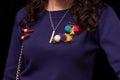 Women's dark purple sweater decorated with colored objects, soft toys on a pin, close-up on a black background