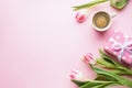 Women`s Day, bouquet of fresh tulips with coffee and gift box on a pink background Royalty Free Stock Photo