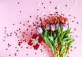 Tulip flowers with small hearts on white wooden background Royalty Free Stock Photo