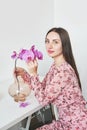 Women`s day, 8 March. Young woman with orchid flowers. Portrait of girl