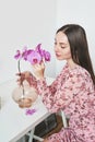 Women`s day, 8 March. Young woman with orchid flowers. Portrait of girl