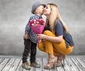 Small son gives his beloved mother a beautiful bouquet of pink roses and kisses mum on the cheek . Spring,Women`s day,mother`s day Royalty Free Stock Photo