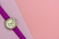 Women`s fashion wrist watch with purple strap. Watch lying on purple paper, also close to a large pink sheet of paper Royalty Free Stock Photo