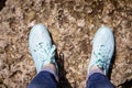 Women s feet in blue sneakers stand on a stone Royalty Free Stock Photo