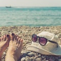 Women`s feet, cap and sunglasses on the beach Royalty Free Stock Photo