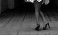 Women& x27;s feet in heels in a dark alley of the city & x28;black and white photo& x29; Royalty Free Stock Photo