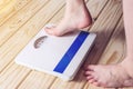 Women's feet are on mechanical scales for weight control