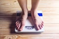 Women's feet are on mechanical scales for weight control