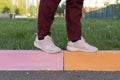 Women`s feet on a multi-colored road curb. kerbstones.