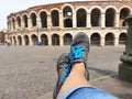 Women`s Feet In Sneakers On The Background Of The Famous Arena In Verona