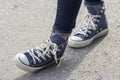 Women`s feet in sneakers are standing on the sidewalk Royalty Free Stock Photo