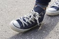 Women`s feet in sneakers are standing on the sidewalk Royalty Free Stock Photo