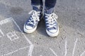 Women`s feet in sneakers are standing on the sidewalk Royalty Free Stock Photo