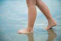 Women`s feet Was walking on a sandy beach at day time. Going forward alone