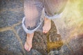 Women's feet in the water on a flooded beach, close-up. The girl stands on the stone bottom after the surf