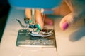 Women`s fingers thread the needle of a sewing machine. Close up. Soft focus Royalty Free Stock Photo