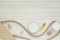 Women`s flatlay with handbag, cosmetics, perfume and minerals on white wooden background.